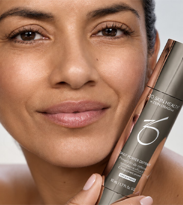Närbild av kvinnas ansikte som håller i Zo Skinprodukt