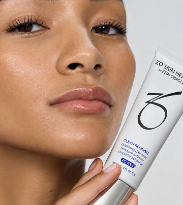 Närbild av kvinnas ansikte som håller i Zo Skinprodukt