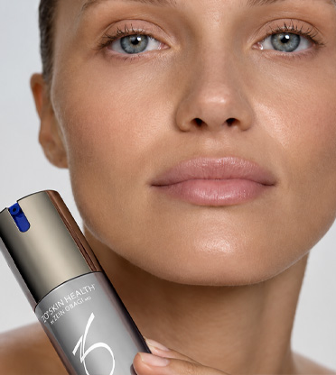 Närbild av kvinnas ansikte som håller i Zo Skinprodukt